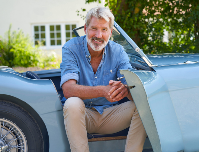 Older man sitting in luxury car.