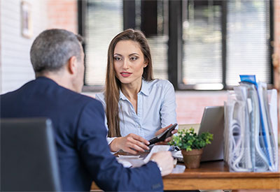 Woman talking to client at desk.