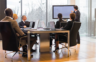 Workers at meeting looking at a presentation.