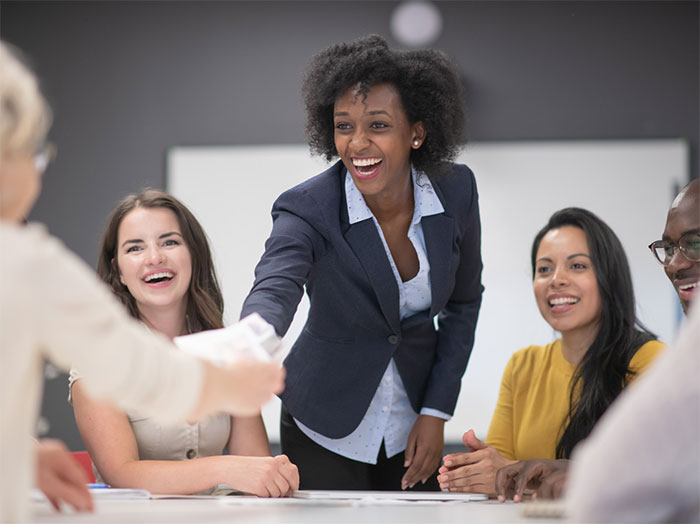 Businesswomen shaking hands across a table.
