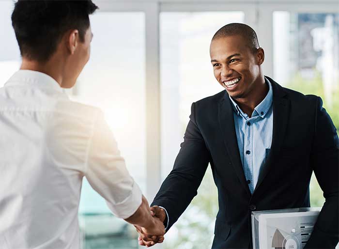 People in a room shaking hands.