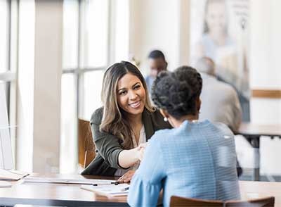 Two women shaking hands.