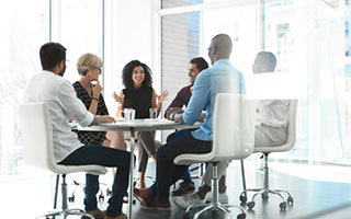 Group of business employees sitting around a breakroom table