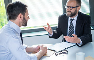 Two business men talking at a conference table